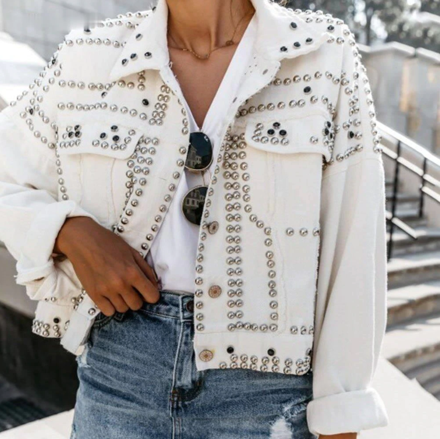 Women's black cropped studded jacket with allover silver studs and raw-edge seams for edgy style