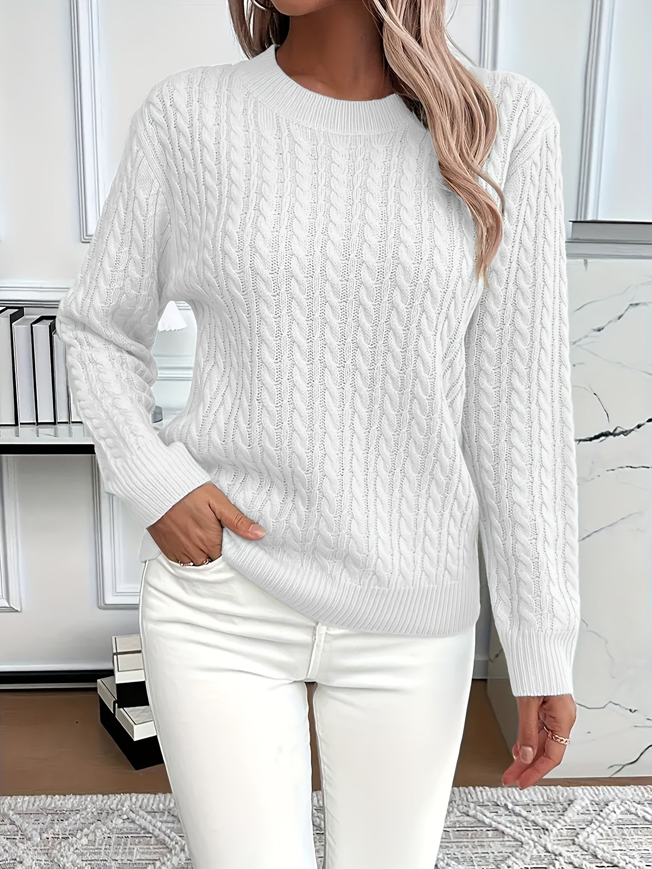 Women's cream cable knit sweater with round neckline, long sleeves, and classic twisted texture pattern