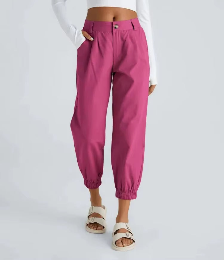Men's tapered jogger pants with crisp front pleats, cinched cuffs, and hidden elastic waistband in neutral tone