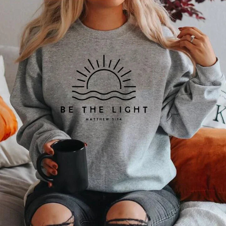 Women's casual grey knit jumper with bold "Be the Light" slogan print, relaxed easy-care fit