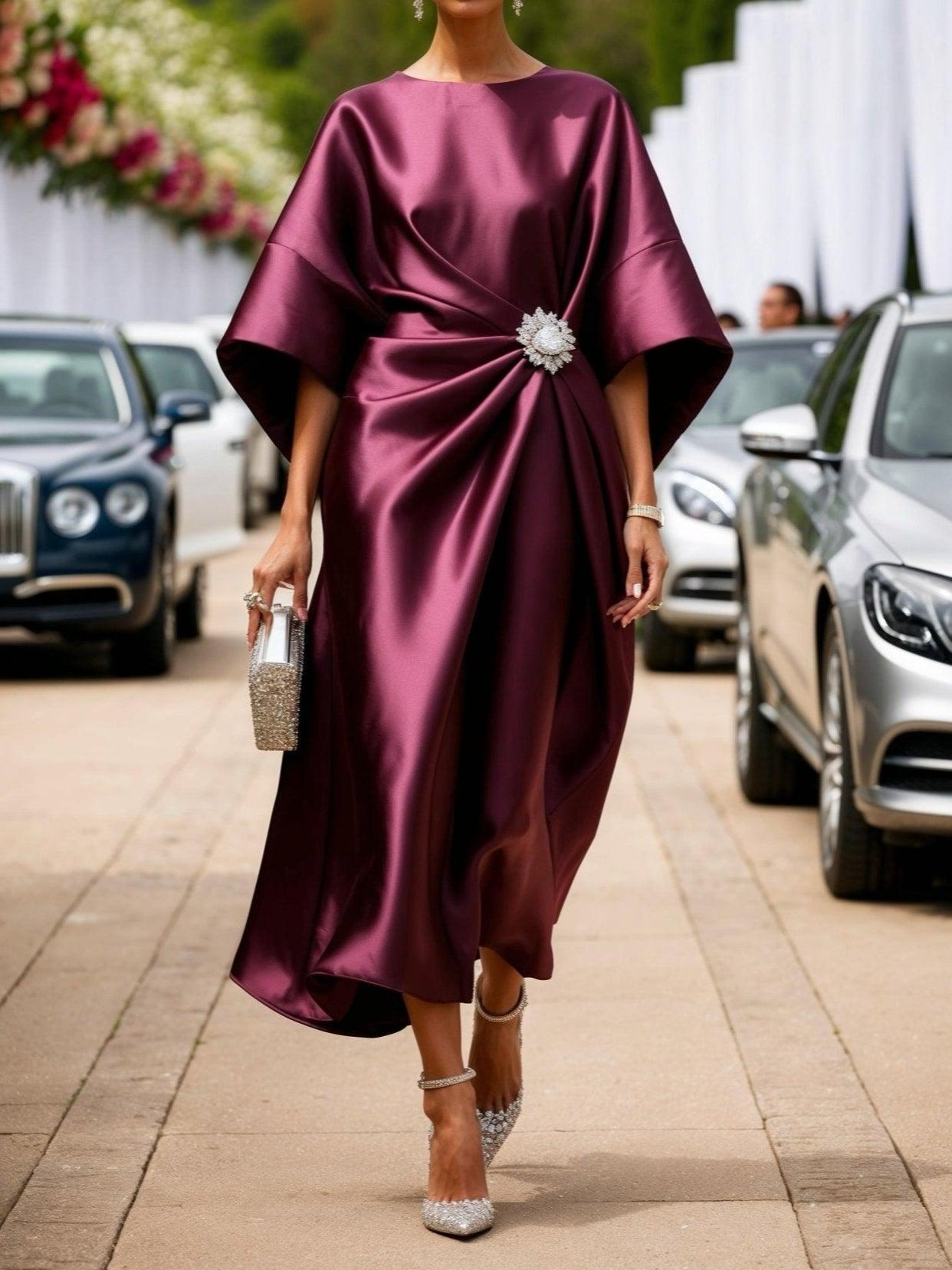 Black draped batwing sleeve evening gown with sculptural silhouette and elegant brooch detail