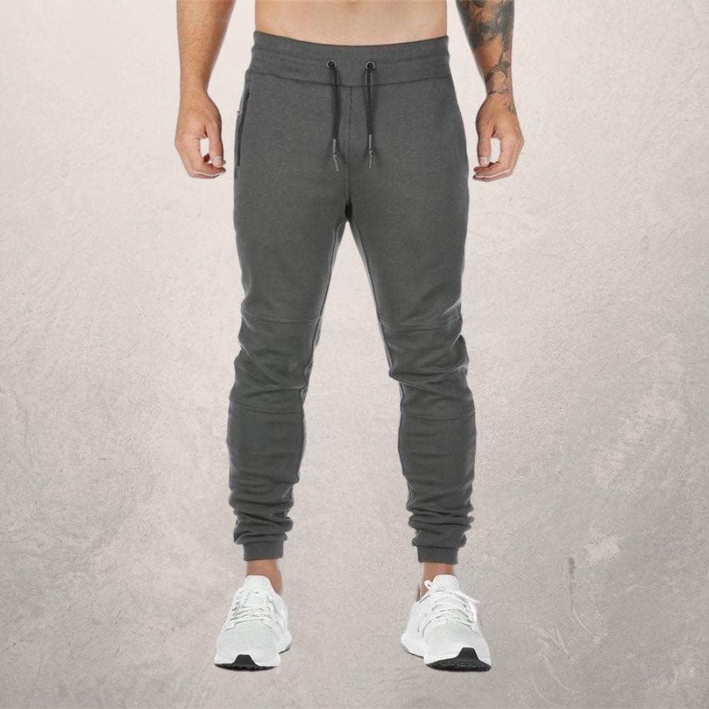 Men's slim fit joggers with elastic drawstring waist, zipper pockets, and ribbed cuffs for a streamlined look