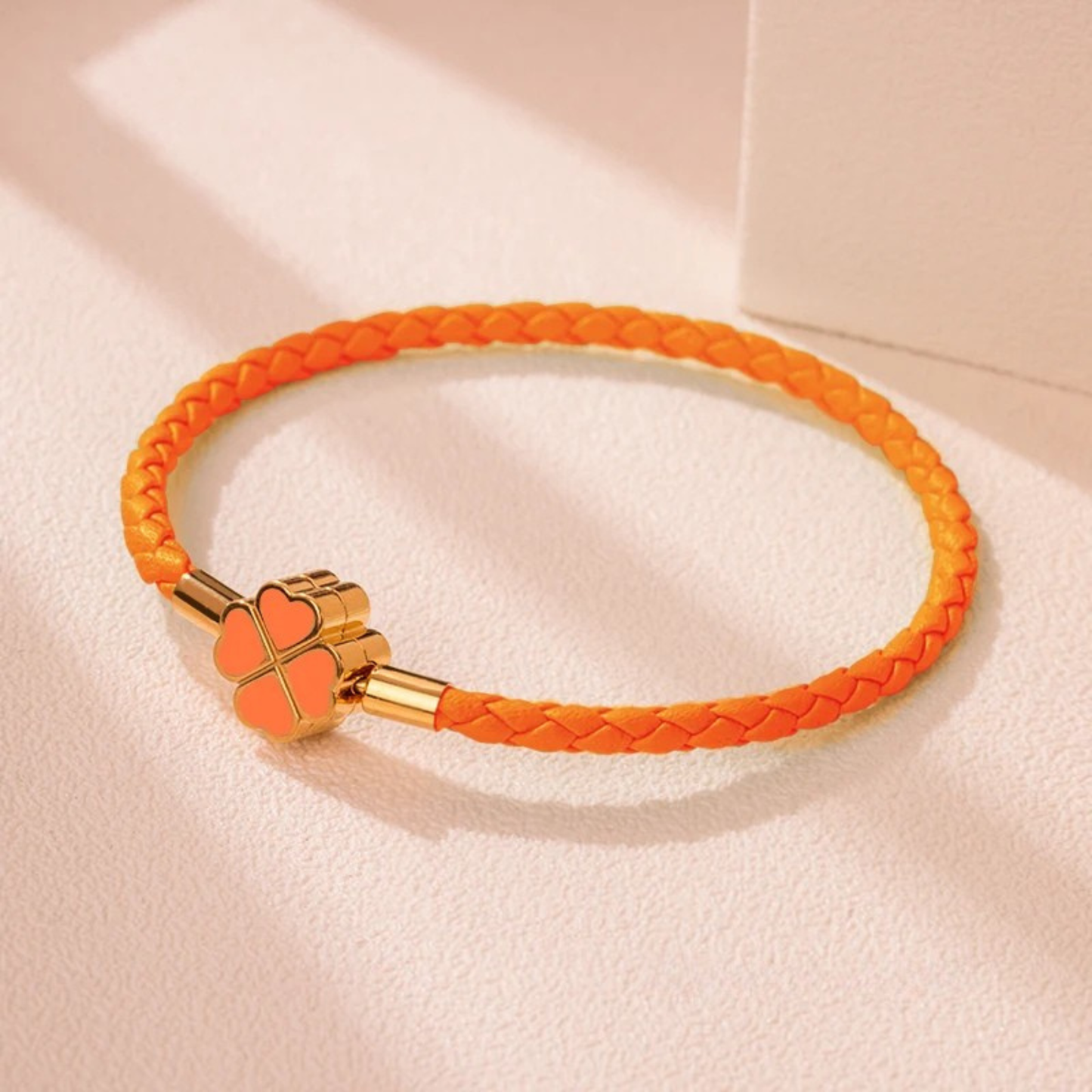 Hand-braided cowhide leather bracelet with 18K gold four-leaf clover charm, hypoallergenic tarnish-resistant