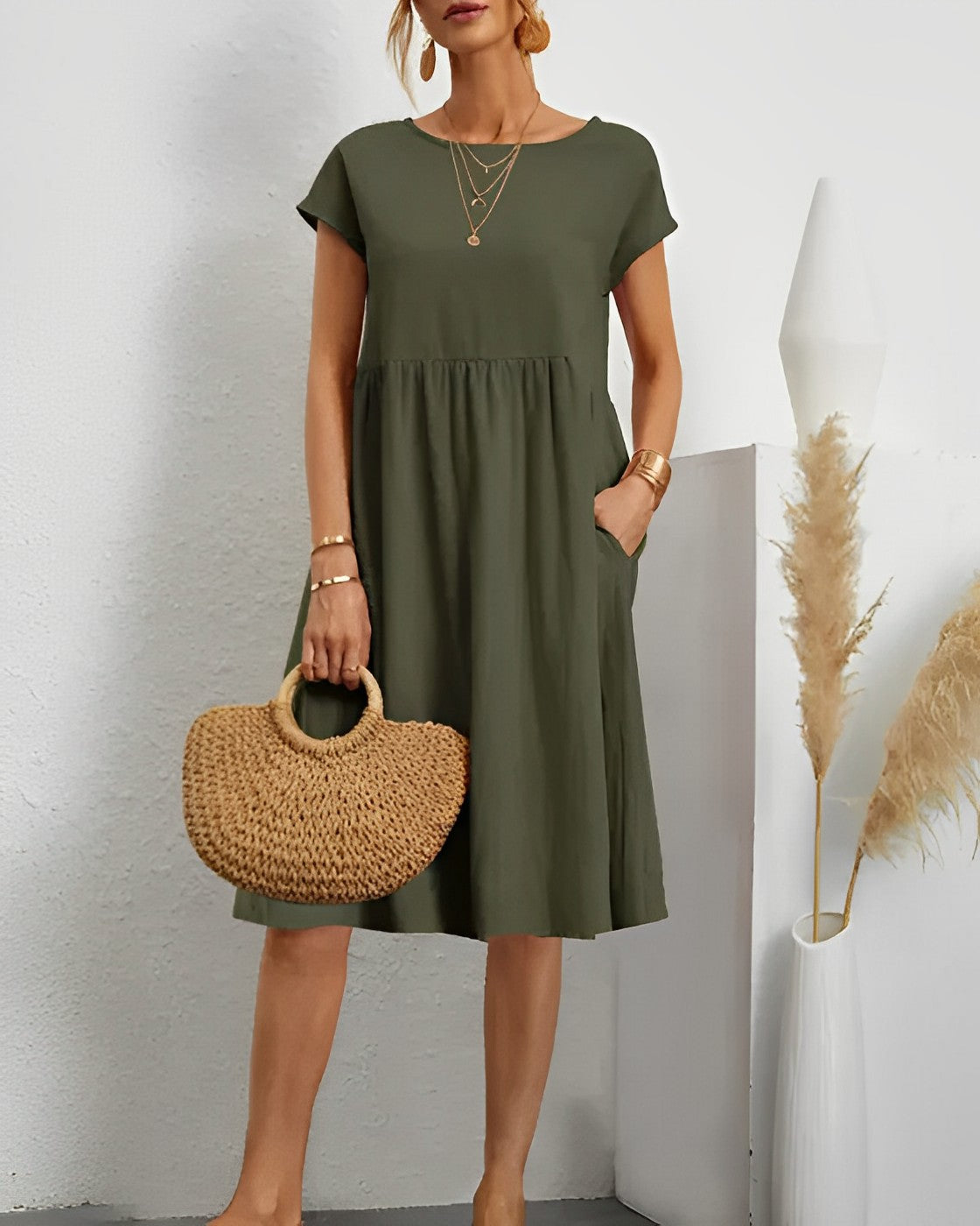 Women's loose-fit midi dress with short sleeves, round neck, and side pockets for effortless style