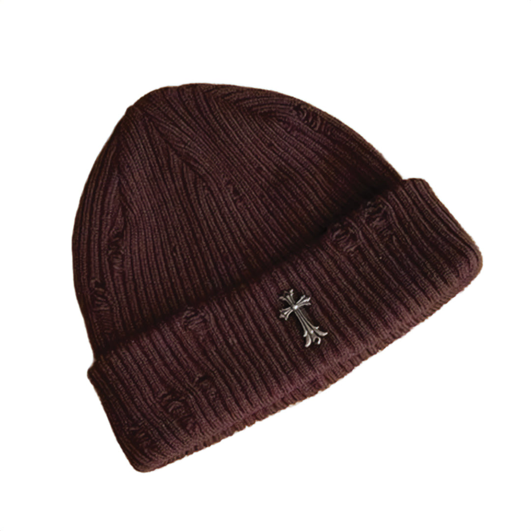 Black ribbed knit beanie with distressed finish and bold metal iron cross emblem for streetwear