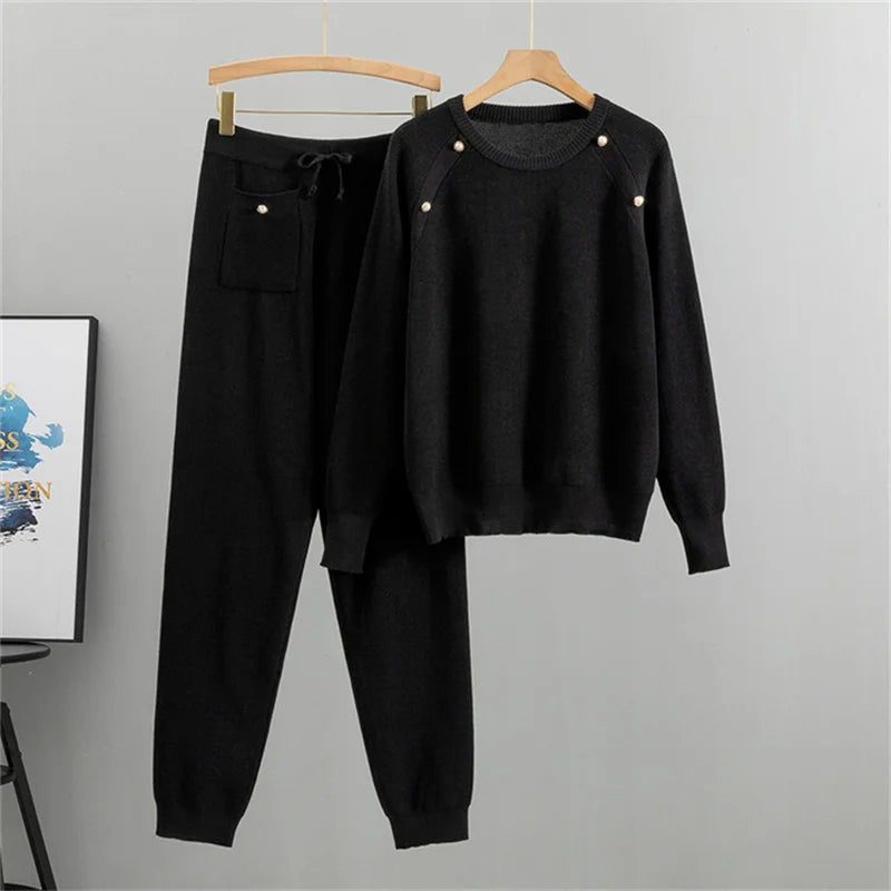 Beige knit two-piece lounge set with pearl accents, relaxed-fit sweater and matching jogger pants