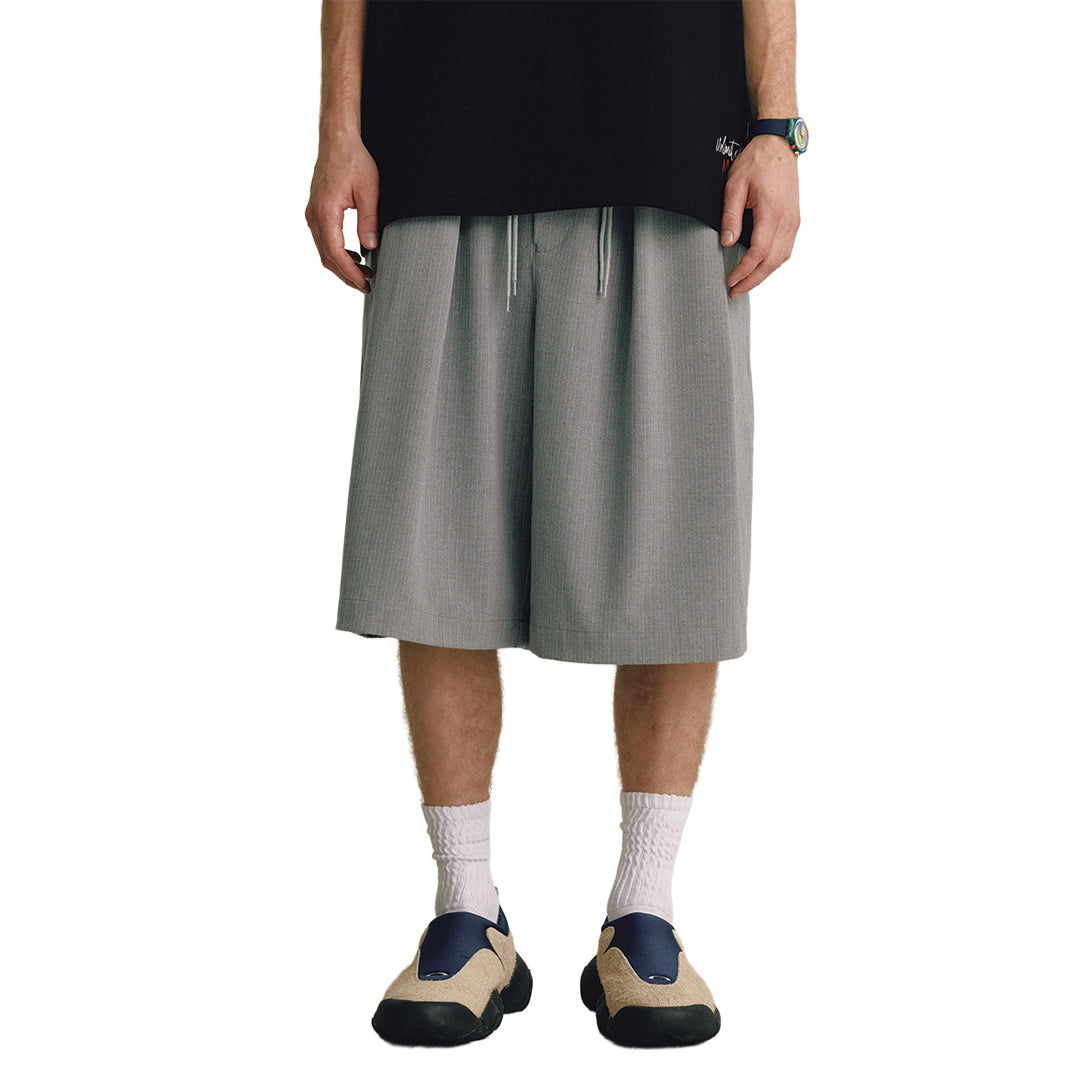 Men's wide-leg calf-length trousers in monochrome with fluid draped pleats and elastic drawstring waist