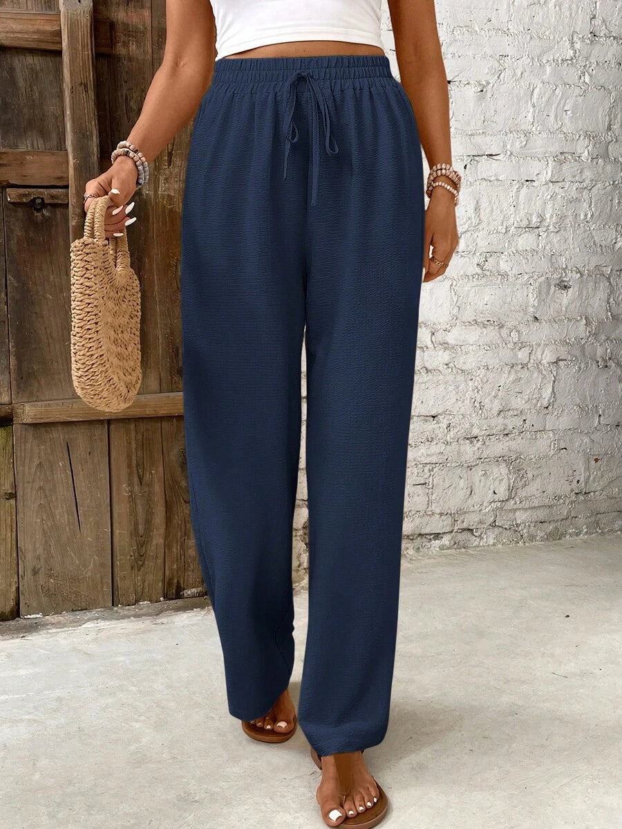 Women's white high-waist lounge pants with airy wide-leg silhouette and wrinkle-resistant lightweight fabric