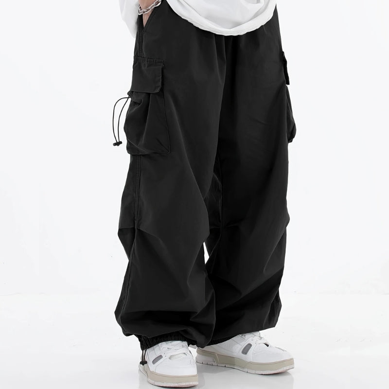 Men's wide-leg cargo pants in neutral tones with drawstring cuffs and multiple utility pockets