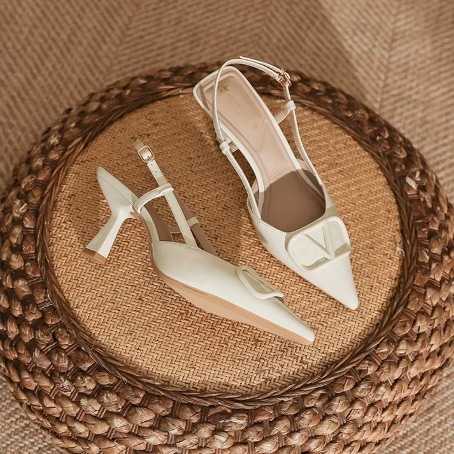 Nude slingback stiletto heels with pointed toe, adjustable ankle strap, and bold oversized buckle