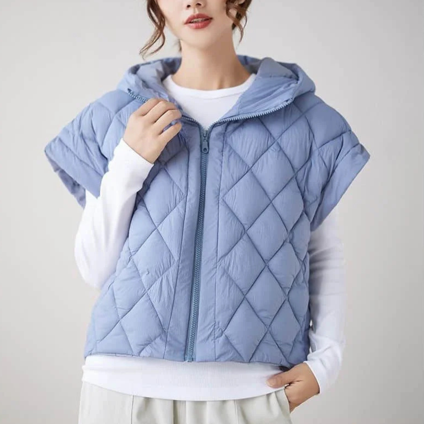 Women's quilted cap sleeve vest with hood, diamond quilt exterior, cropped silhouette, soft lining