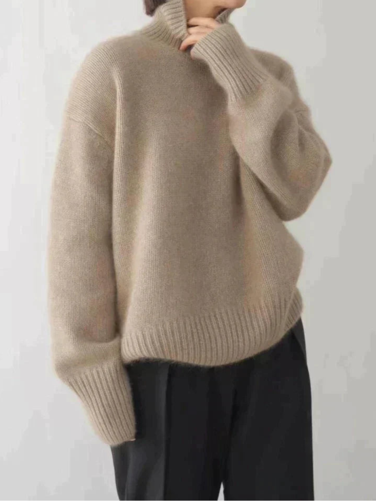 Women's oversized turtleneck sweater in neutral tone, relaxed elegant fit with high collar for fall winter