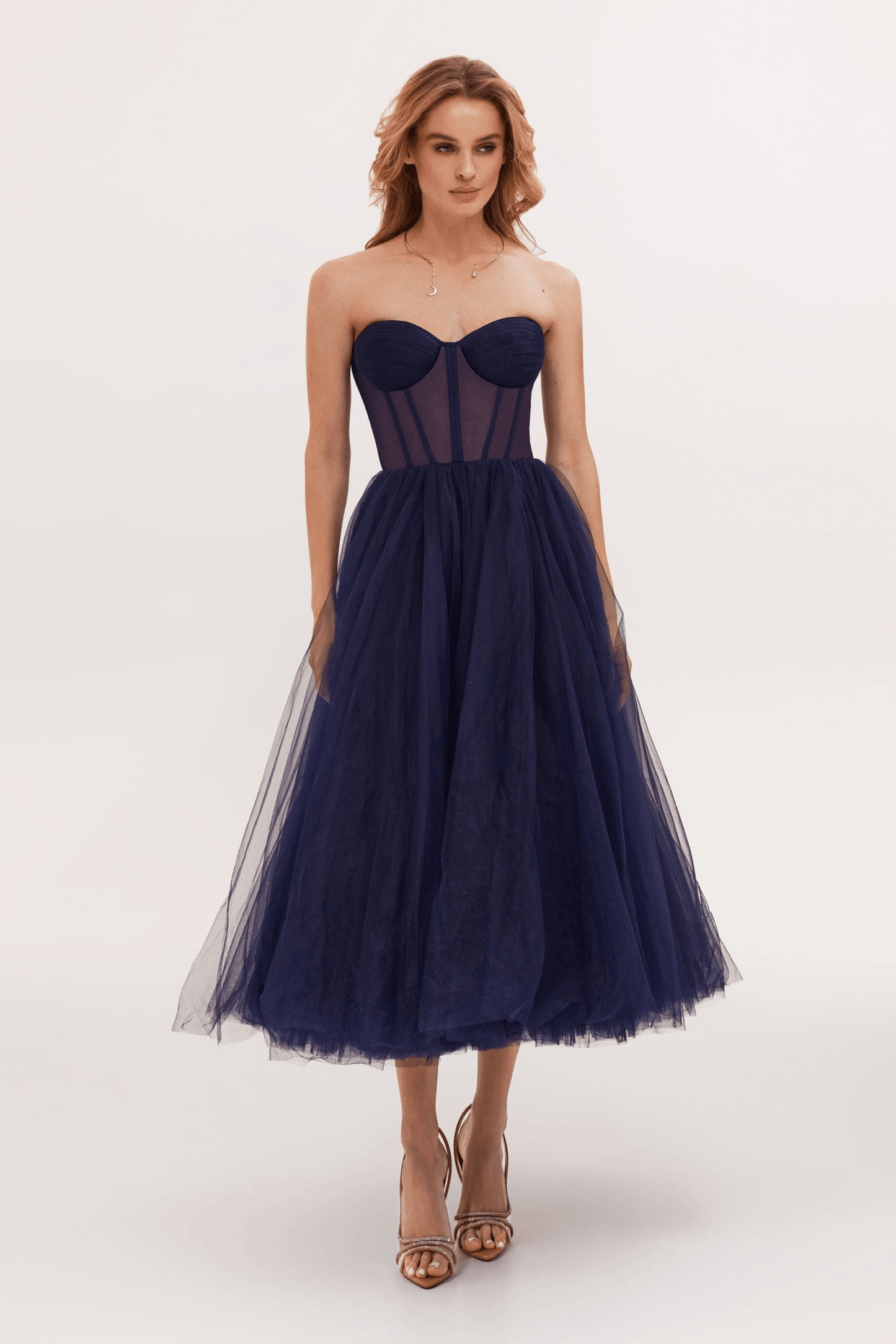 Black strapless tulle evening gown with structured bodice and voluminous multi-layer skirt
