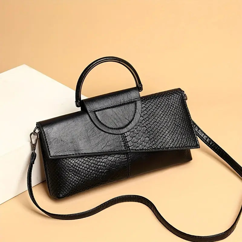 Black structured vegan leather handbag with bold faux snakeskin embossed panel and detachable strap