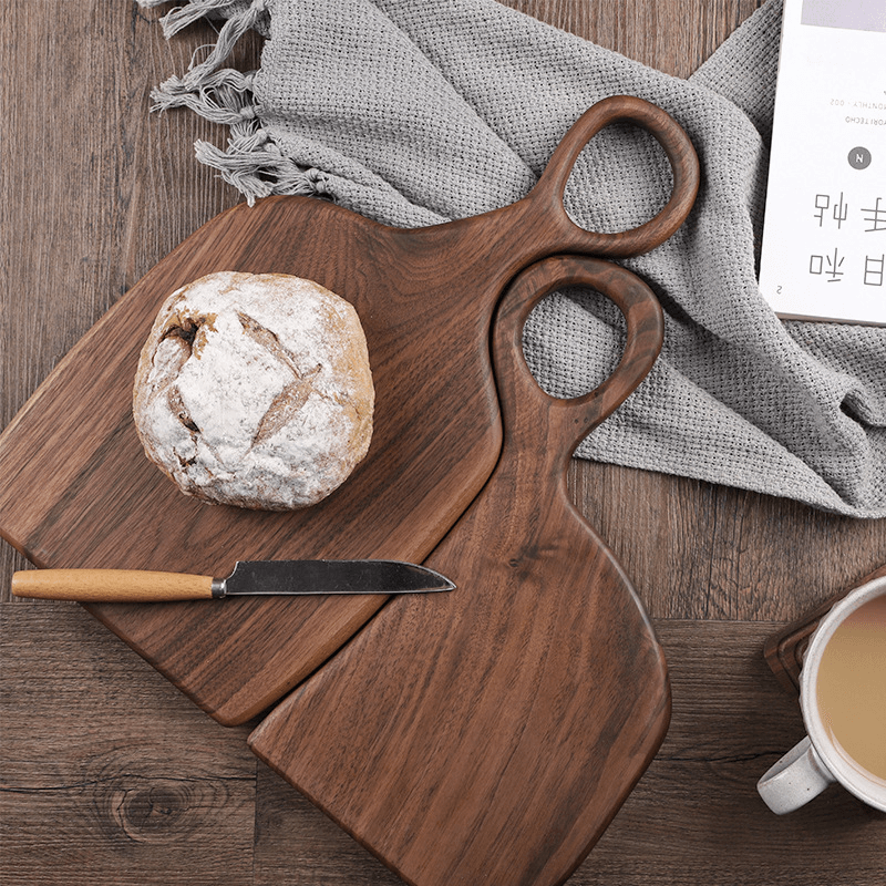 Solid walnut wood cutting board rounded handle minimalist kitchen display piece natural grain