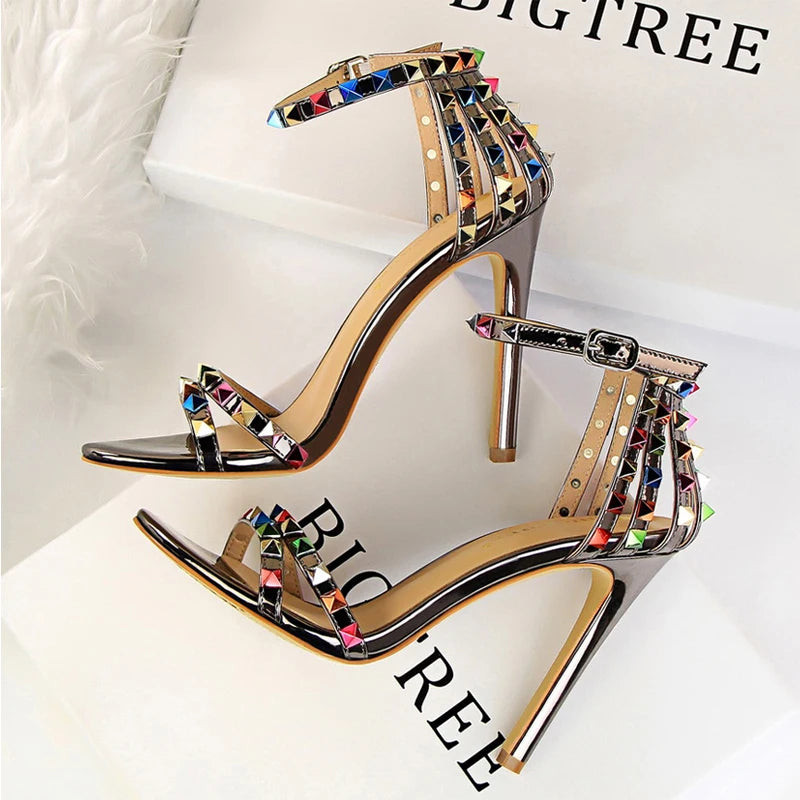 Metallic leather stiletto heels with pyramid studs, triple ankle straps, and sculpted heel for nightlife glam