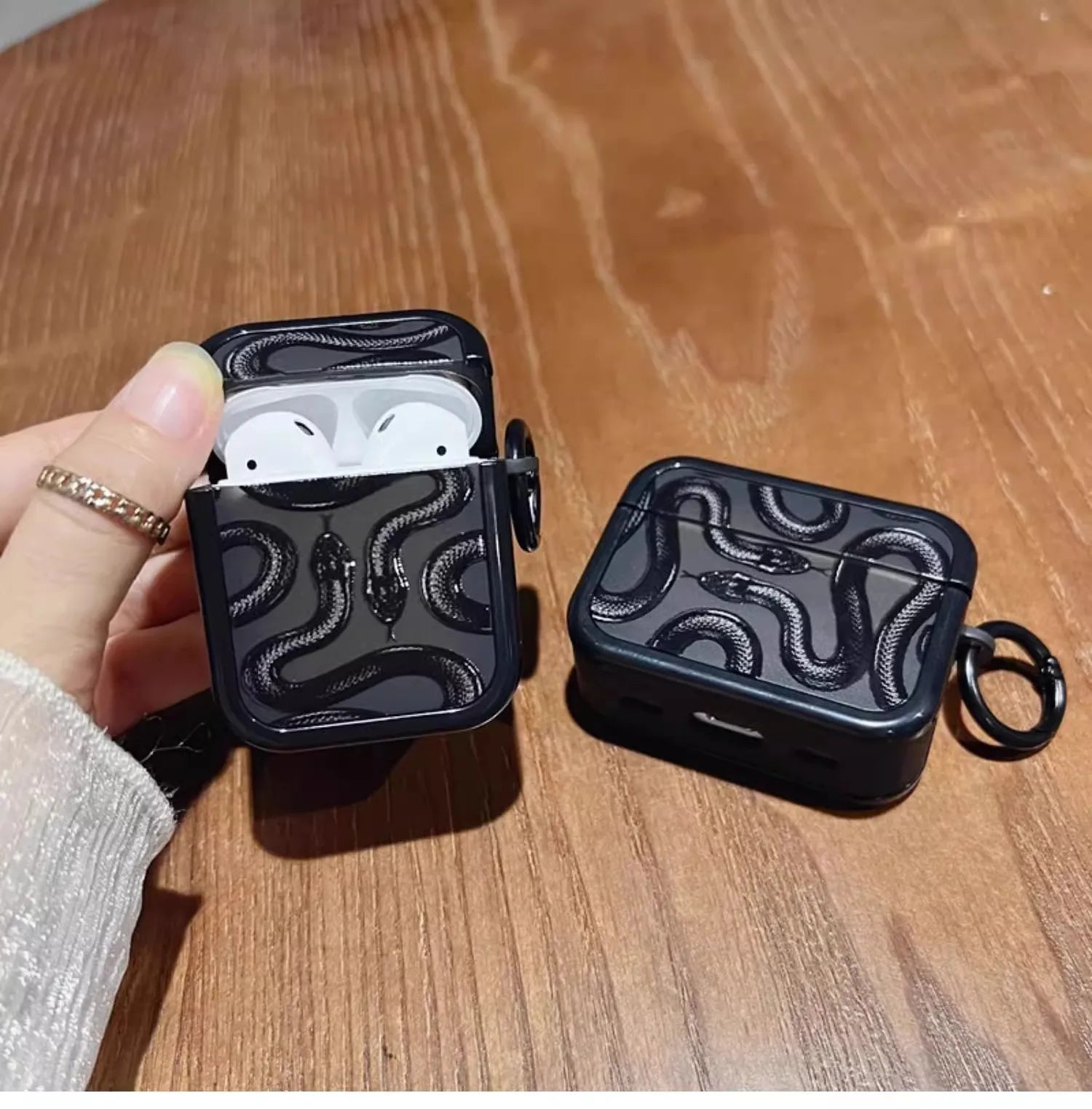 Matte black silicone AirPods case with serpent motif, shock-absorbent grip for active use