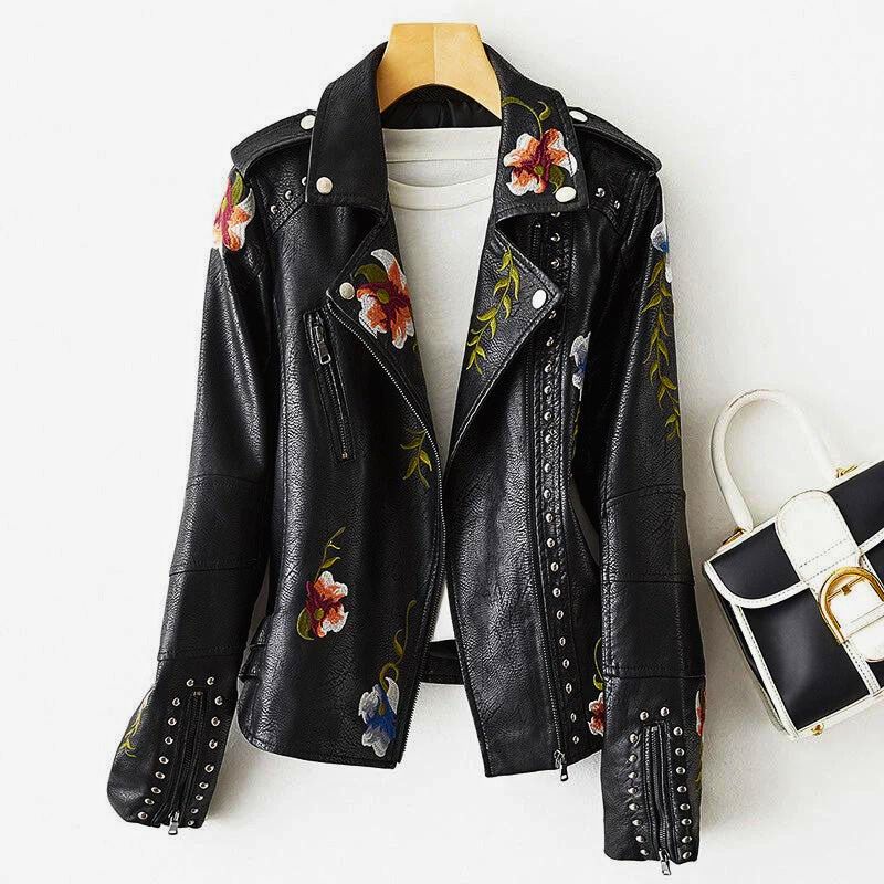 Black leather moto jacket with floral embroidery, silver studs, and bold feminine edge