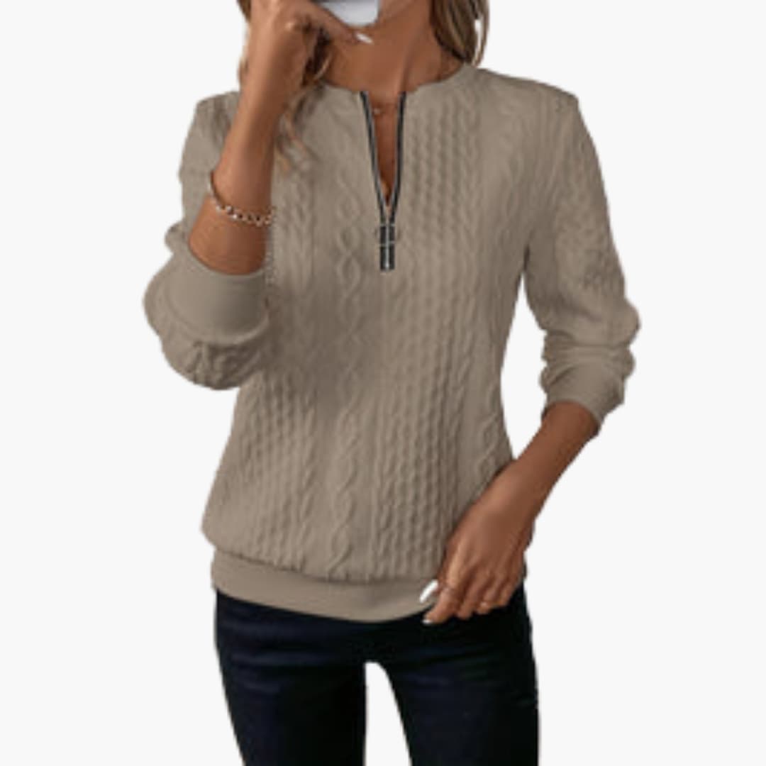 Women's cable knit pullover sweater with front zip neckline, long sleeves, and ribbed cuffs