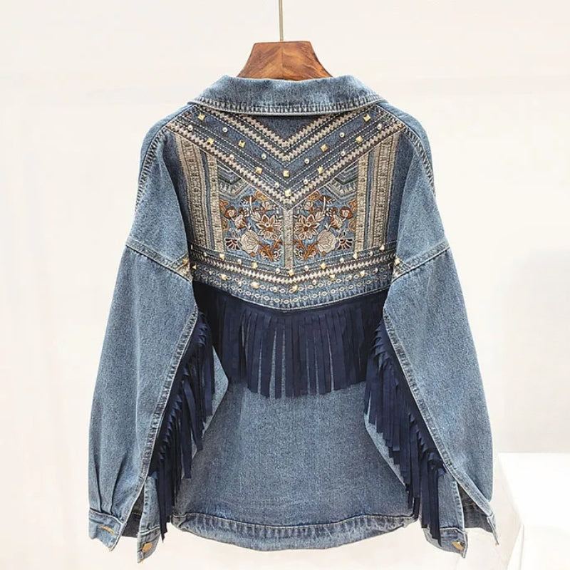 Oversized blue denim jacket with embroidered back panel, suede fringe accents, and Western-inspired structured fit