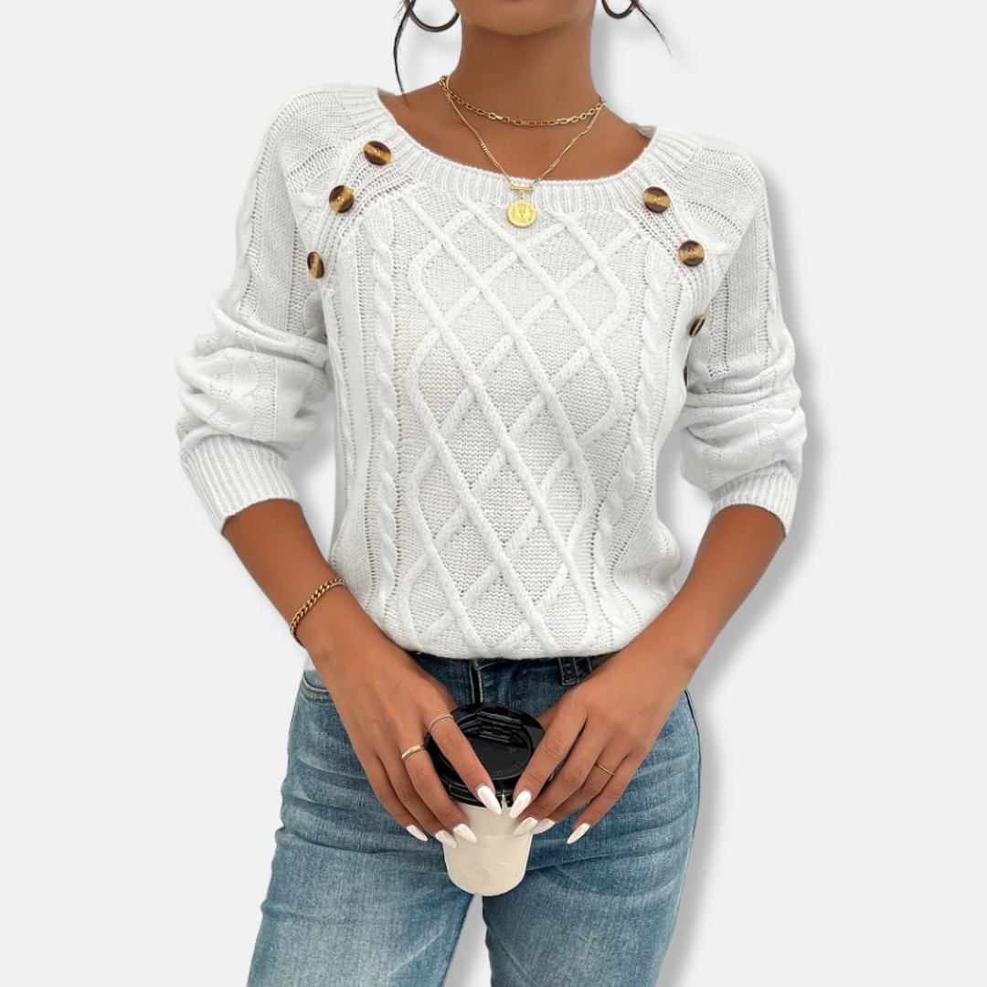 Women's relaxed fit cable knit top with dropped shoulders, ribbed cuffs, and button accent detail