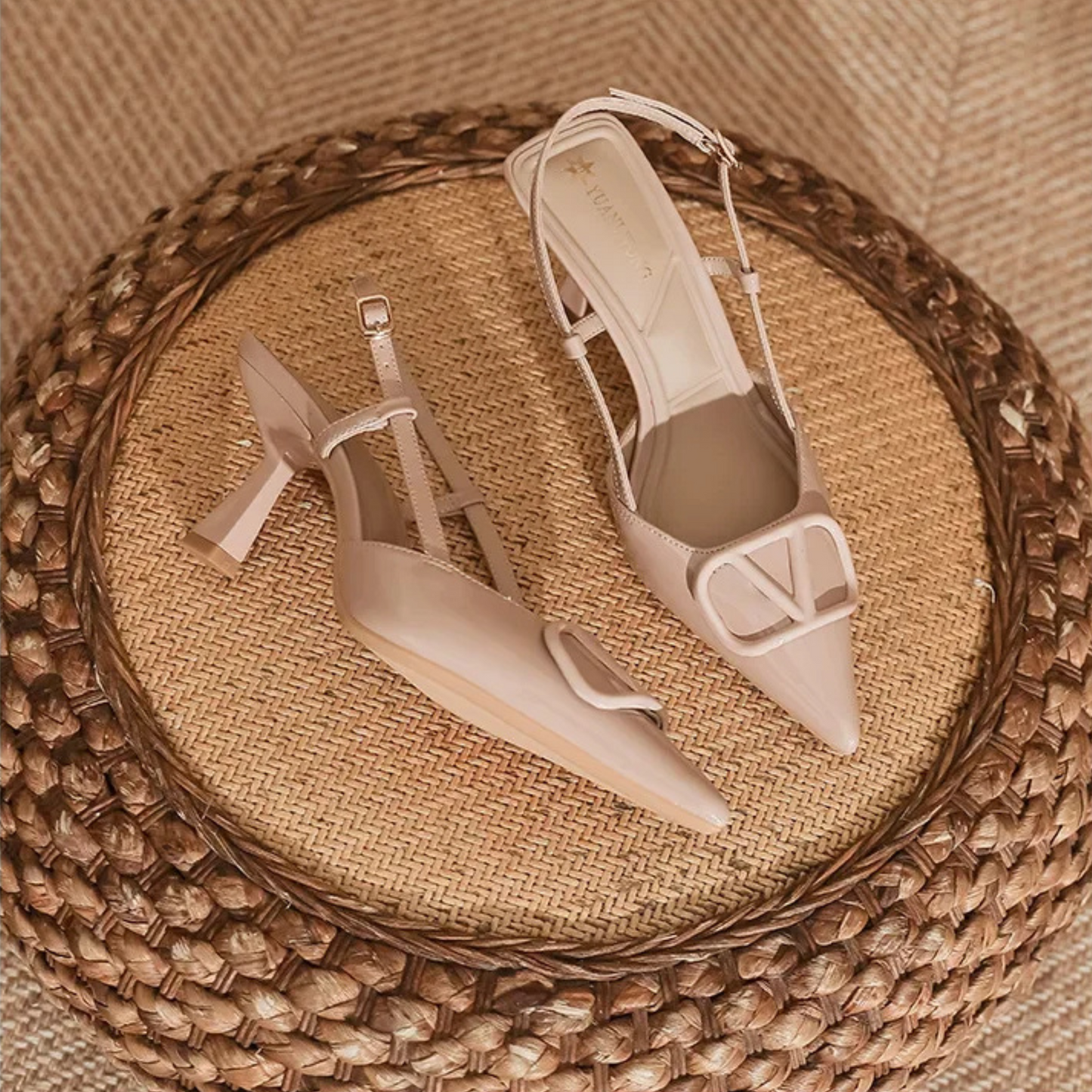 Nude slingback stiletto heels with pointed toe, adjustable ankle strap, and bold oversized buckle
