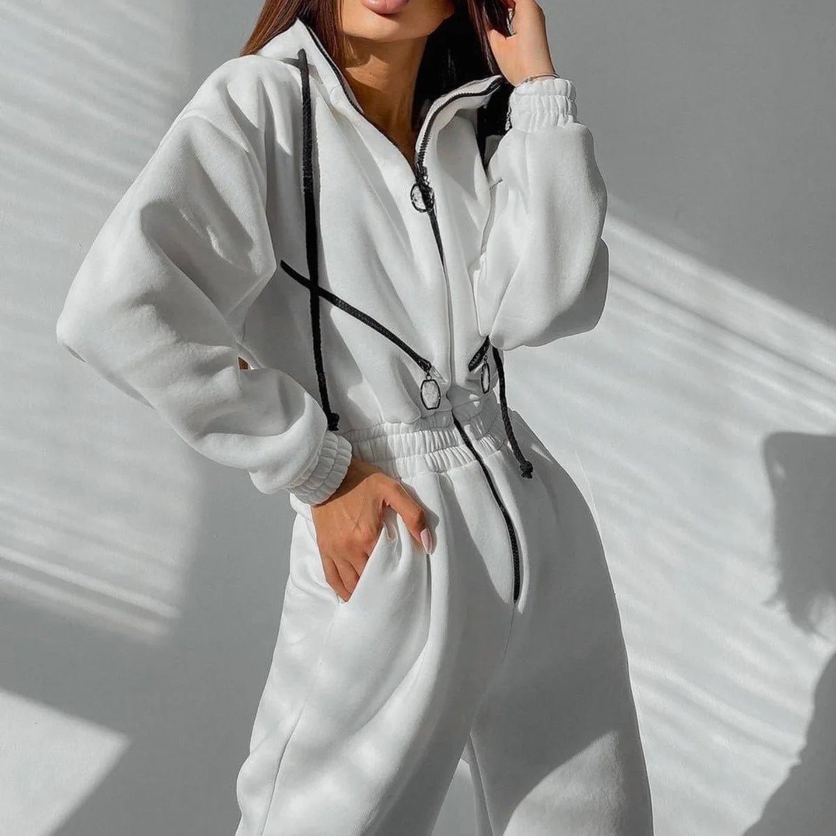Gray heavyweight fleece zip-up jumpsuit with cinched waist, adjustable hood, and relaxed athletic cut