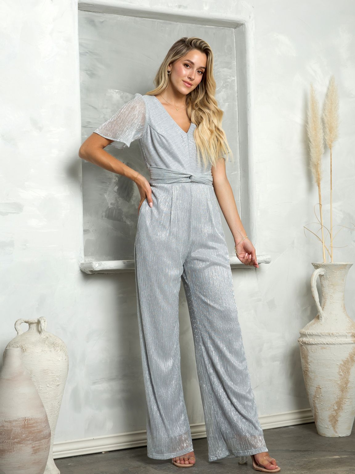 Women's metallic silver formal evening jumpsuit with winged sleeves, back zip, and pockets