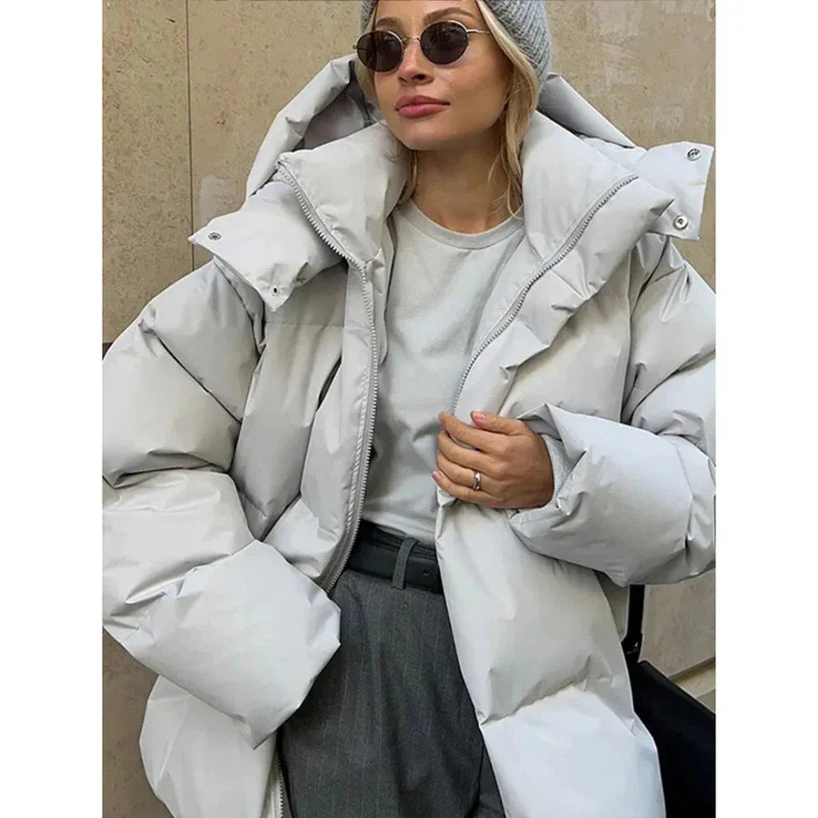 Women's oversized quilted puffer jacket with padded hood, mid-length winter warmth, street-ready style