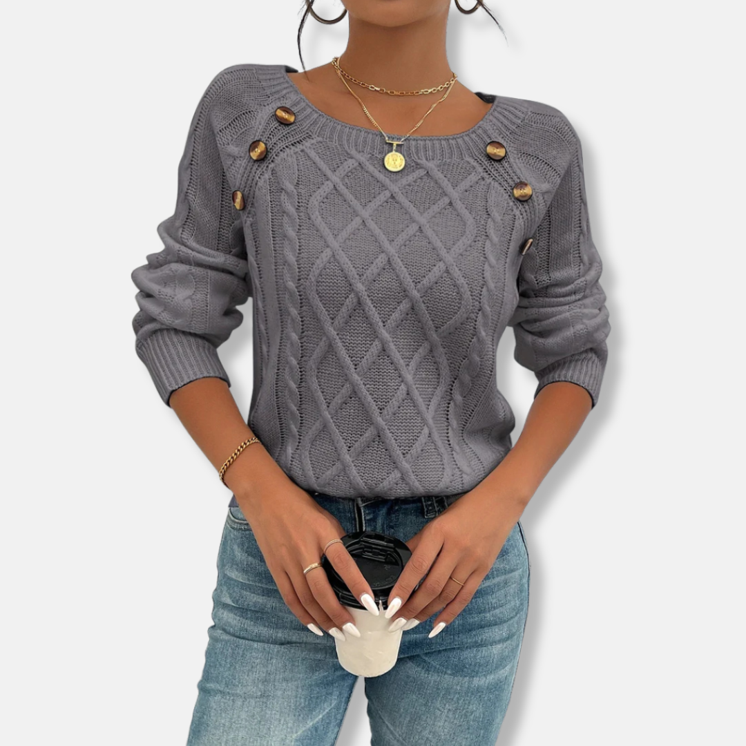 Women's relaxed-fit cable knit top with dropped shoulders, ribbed cuffs, and button accent detail