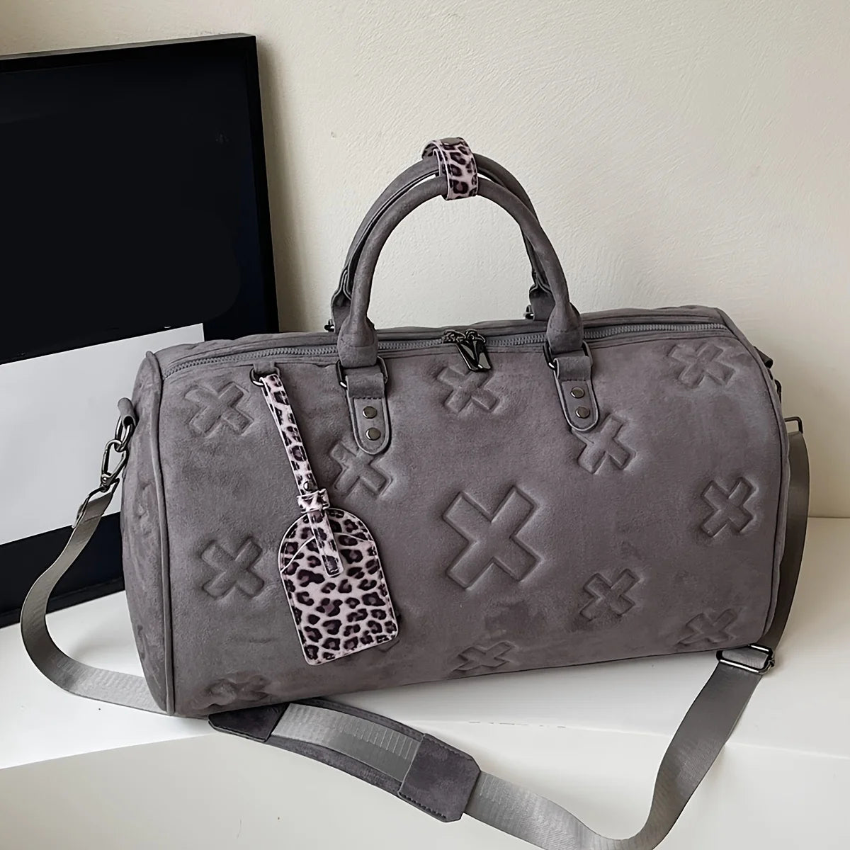 Tan suede weekender bag structured barrel silhouette embossed texture detachable strap unisex leather finish