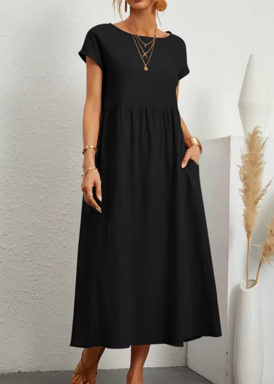 Women's relaxed midi dress with gathered waist, short sleeves, soft flowy fabric, and side pockets