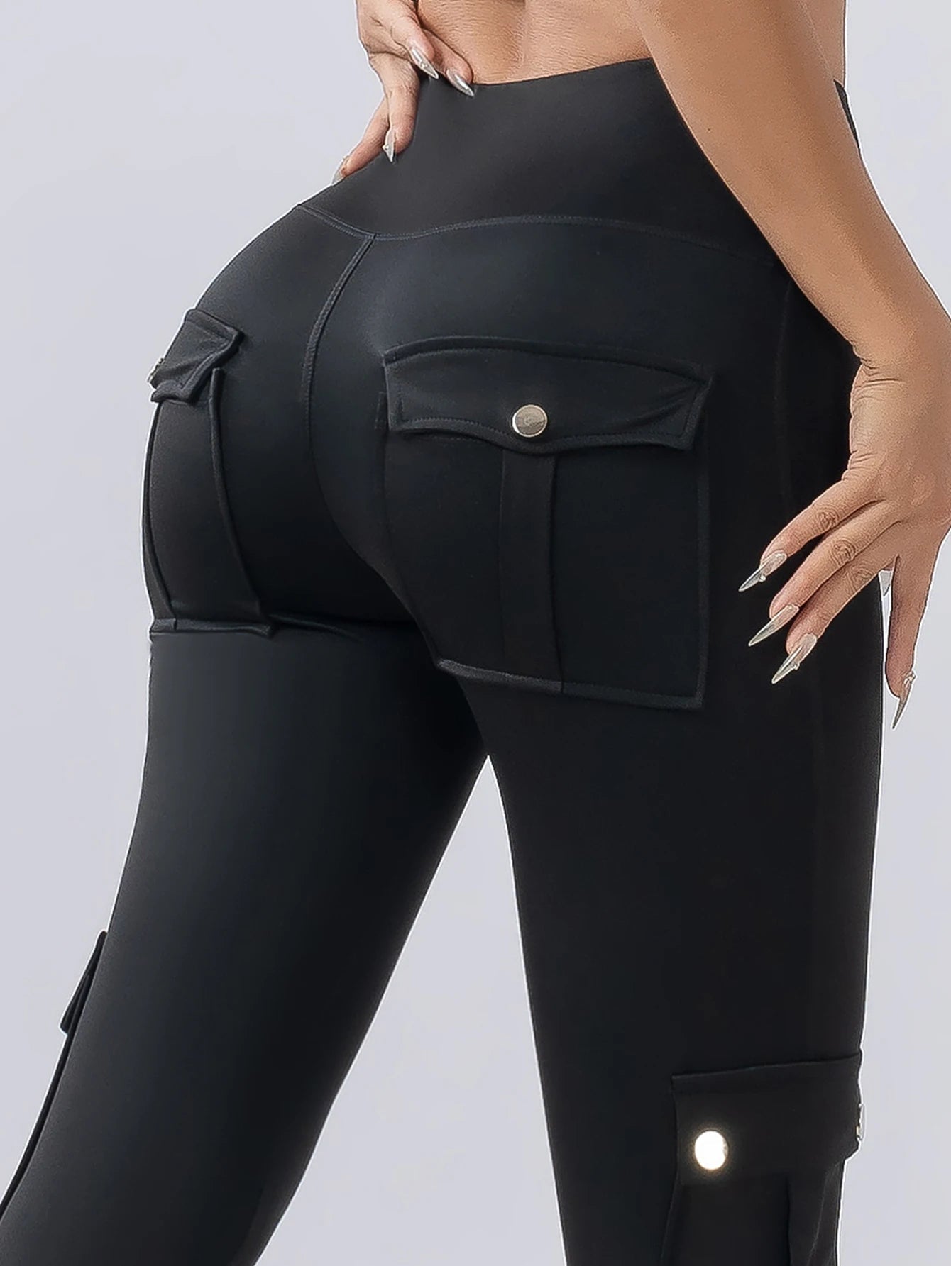 Women's black high-waisted cargo legging with contour fit and secure snap pockets for all-day wear