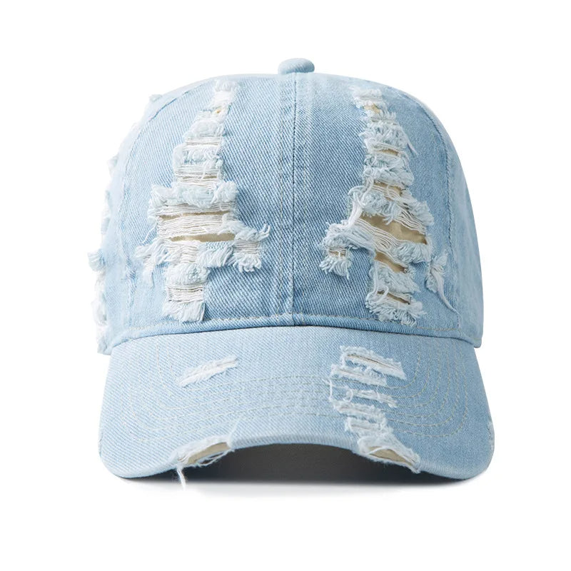 Sun-faded distressed denim cap with heavy shredded rips and adjustable fit for streetwear