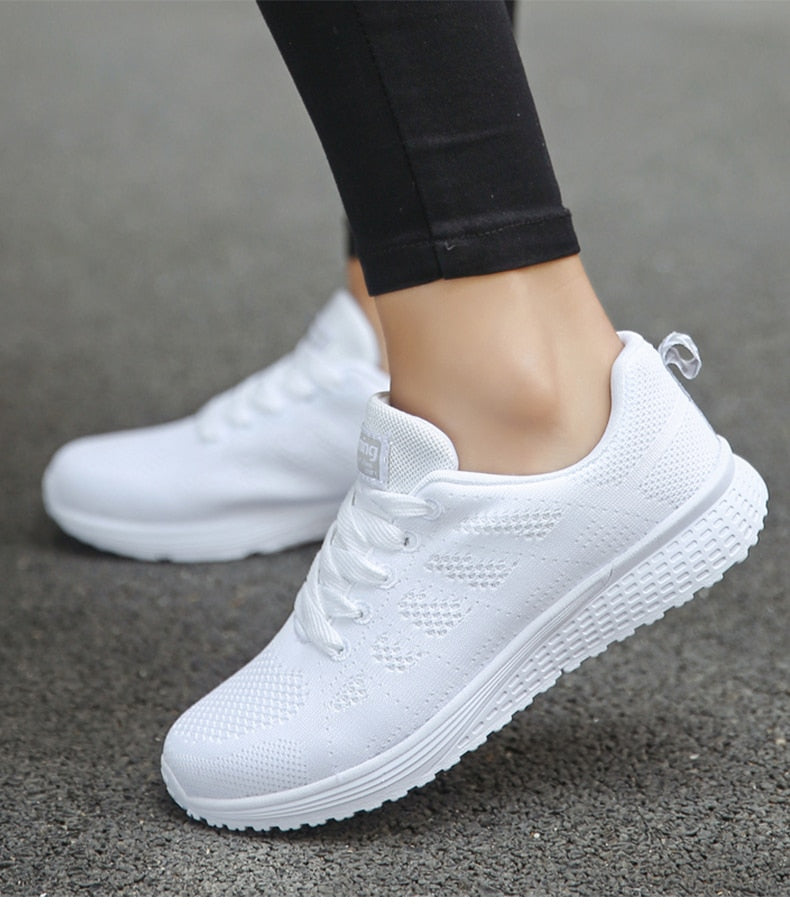 Women's white orthopedic walking sneakers with breathable mesh upper, arch support, and secure lace fit