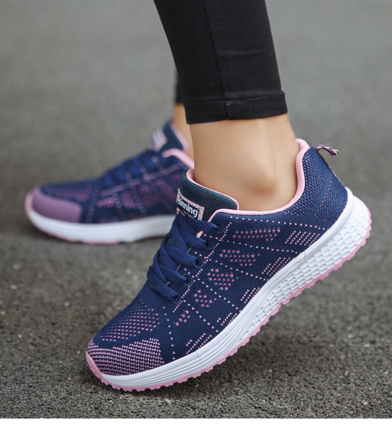 Women's white orthopedic walking sneakers with breathable mesh upper, arch support, and lace-up fit