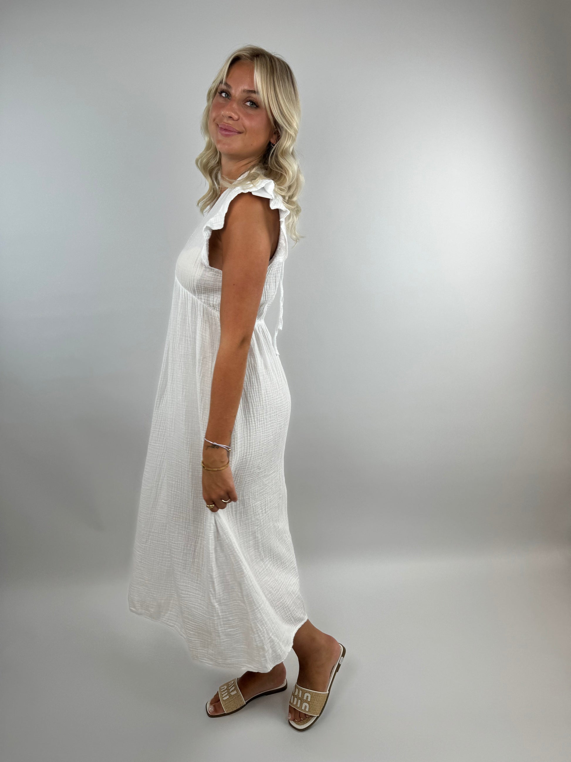 Pia white muslin midi dress with elegant flowing silhouette and delicate feminine ruffles
