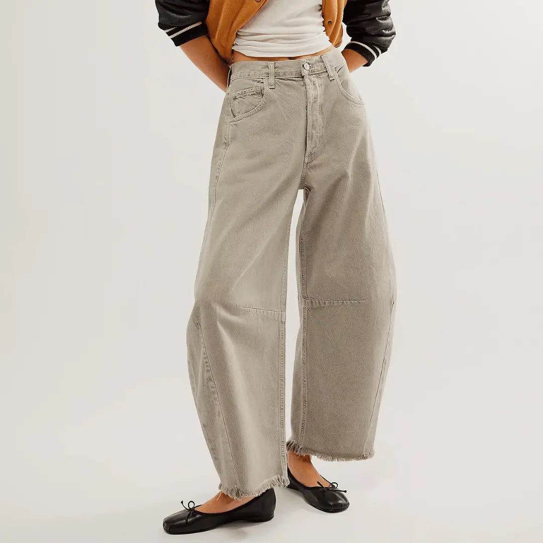 Vintage high-rise wide-leg distressed denim jeans with 90s flare silhouette in classic blue wash
