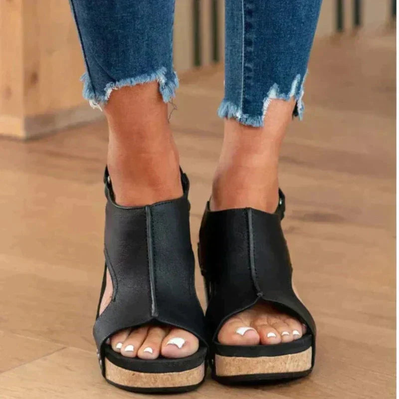 Women's open-toe cork wedge sandals with adjustable strap, stud accents, and cutout details