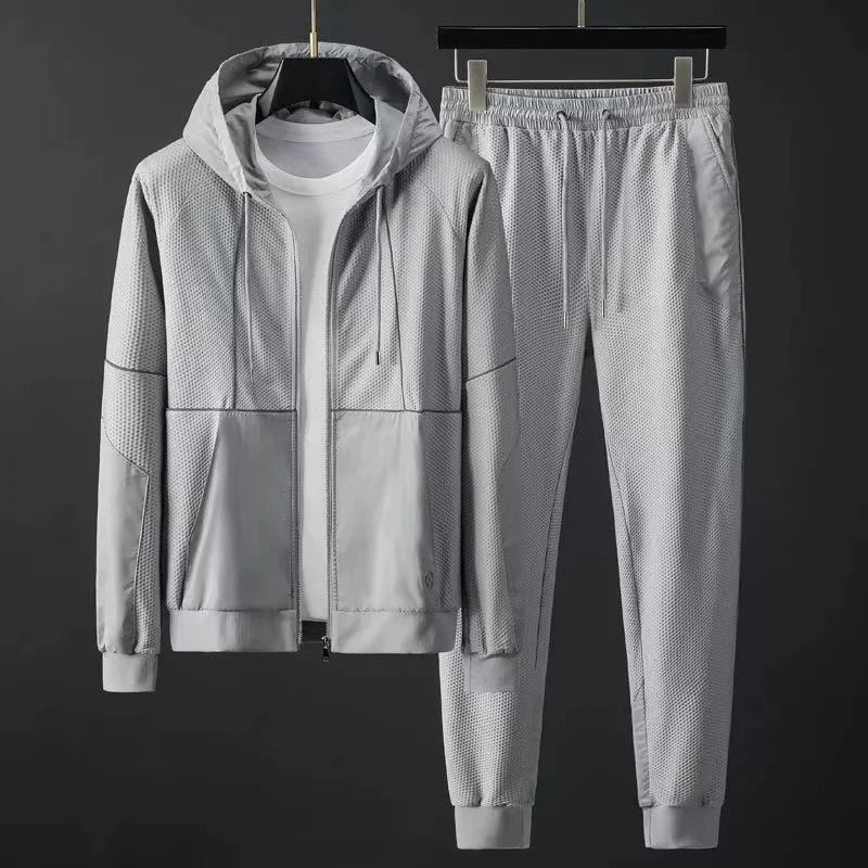 Black techwear tracksuit set with breathable mesh hoodie jacket and matte paneling for urban athletes