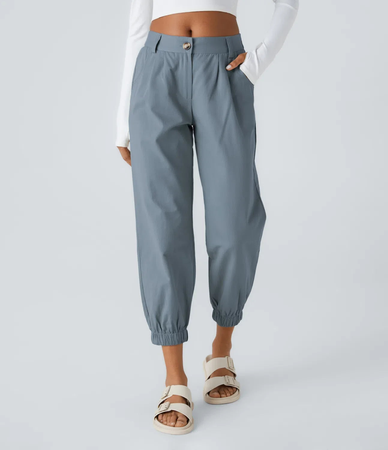 Charcoal tapered jogger pants with crisp front pleats, cinched cuffs, and hidden elastic waistband
