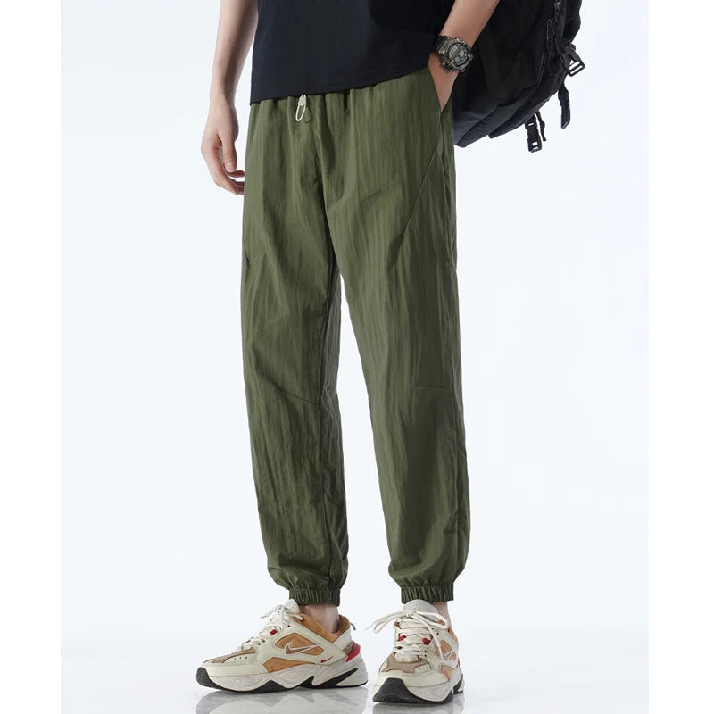 Men's black tapered nylon jogger, lightweight quick-dry activewear with sleek modern silhouette