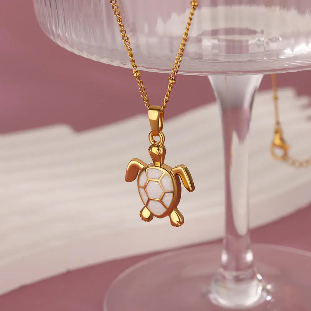 Gold-tone stainless steel turtle pendant necklace with shimmering enamel inlay and adjustable chain