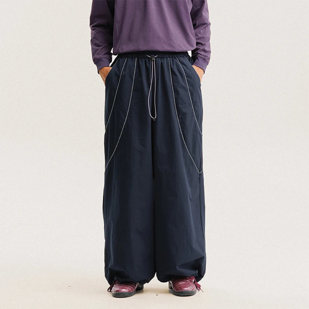 Black wide-leg reflective trousers water-resistant nylon urban outdoor performance pants with stripe detail