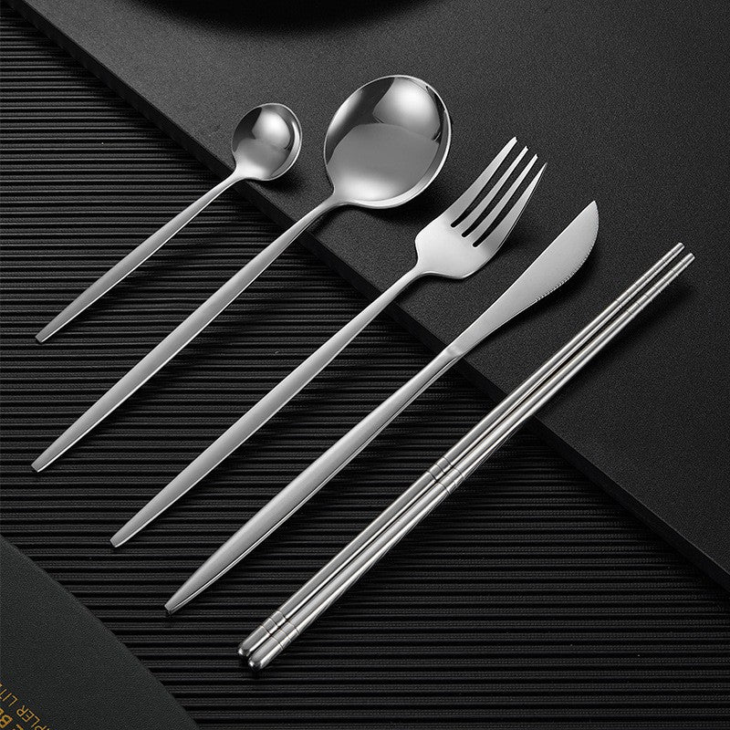 Gold finish stainless steel cutlery set with matte black handles, modern luxury dining