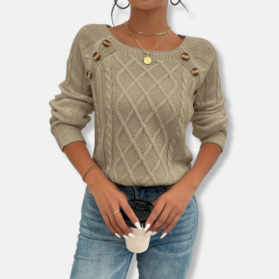 Women's relaxed-fit cable knit top with dropped shoulders, ribbed cuffs, and button accent detail