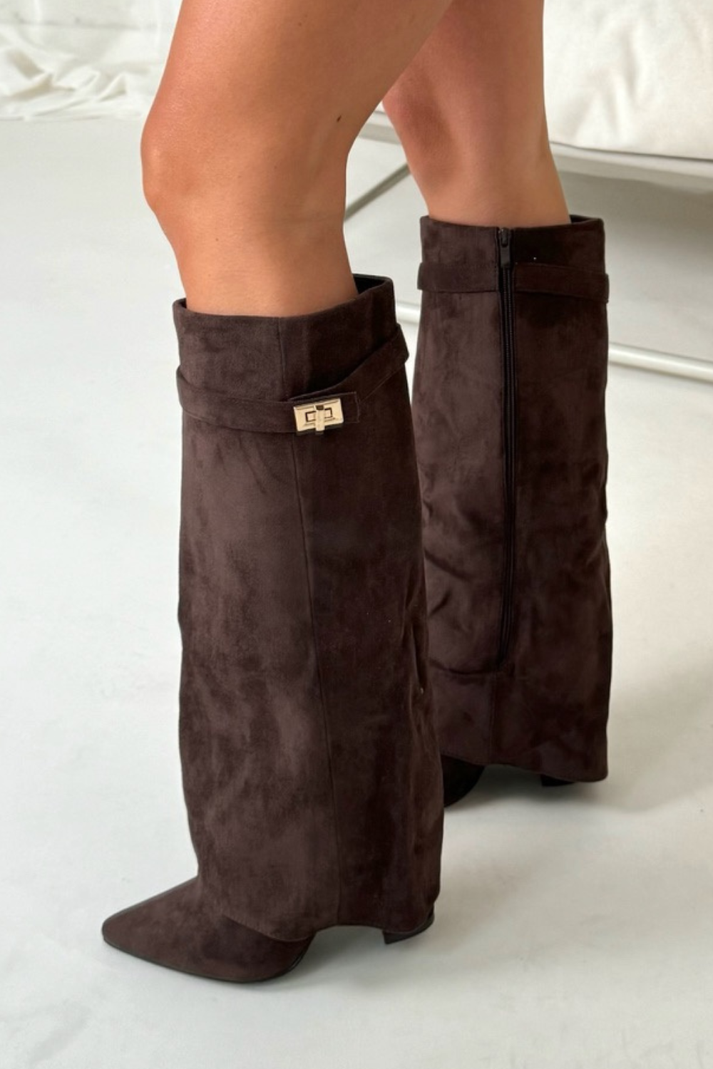 Women's brown suede slouchy knee-high boots with pointed toe and buckle detail for evening glamour