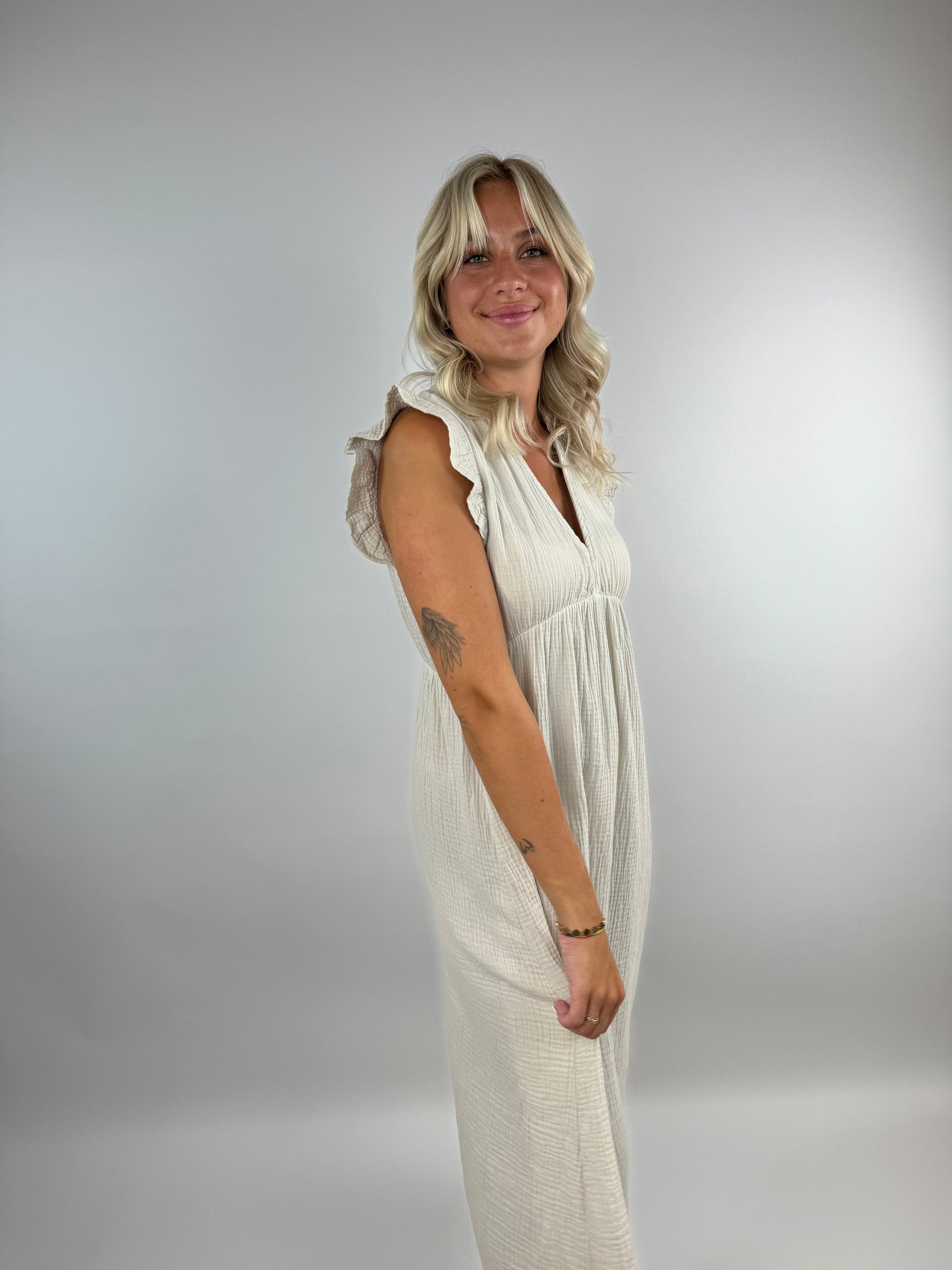 Ivory muslin midi dress with flowing silhouette, delicate ruffles, and lightweight airy fabric for special occasions