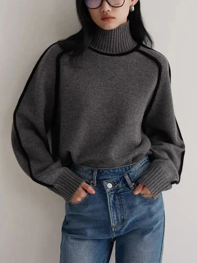 Women's contrast knit turtleneck sweater with bold seams, cozy fit, versatile style