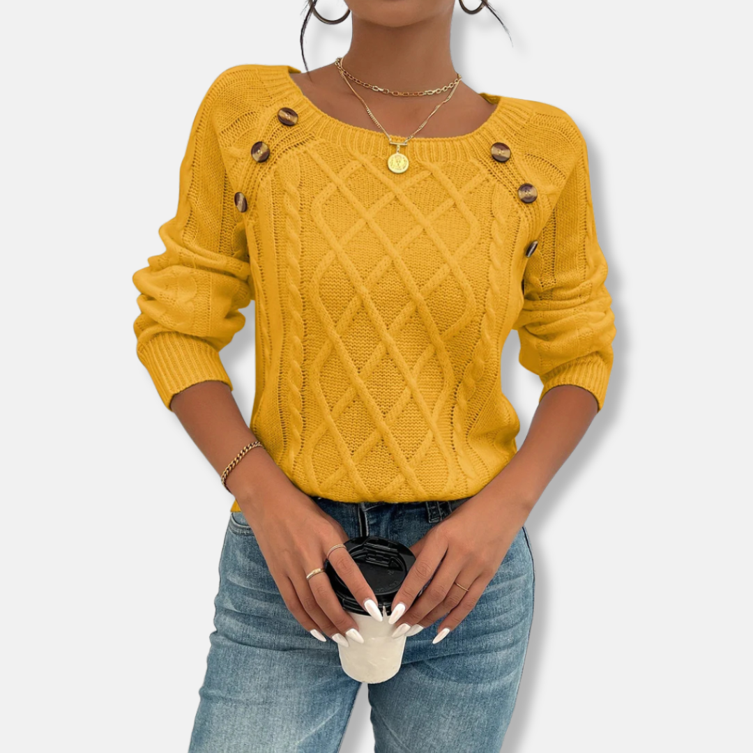 Women's relaxed fit cable knit top with dropped shoulders, ribbed cuffs, and button accent detail